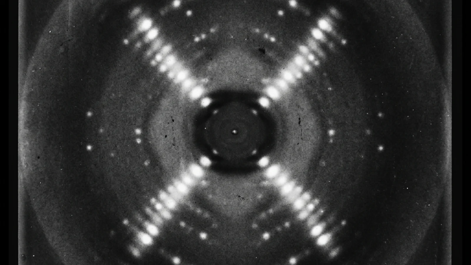 Rosalind Franklin's Photograph 51: an X-ray diffraction image of crystallized DNA fibers showing the characteristic cross-shaped pattern of spots that revealed the double-helix structure