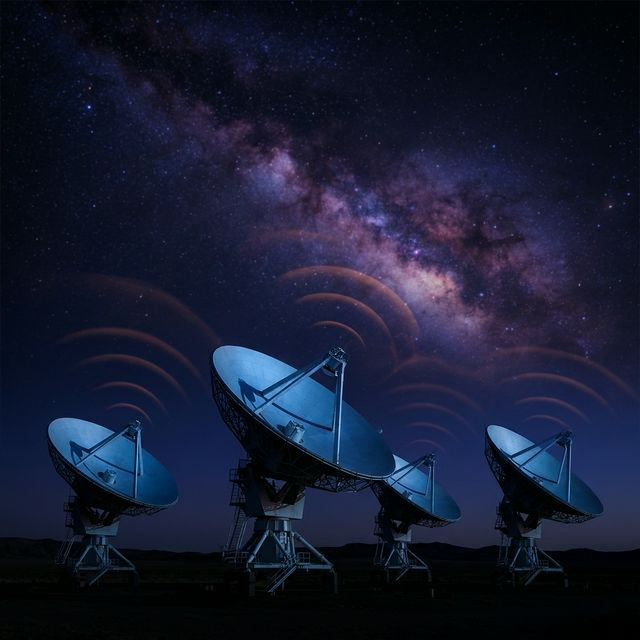 Array of radio telescope dishes pointed at starry sky
